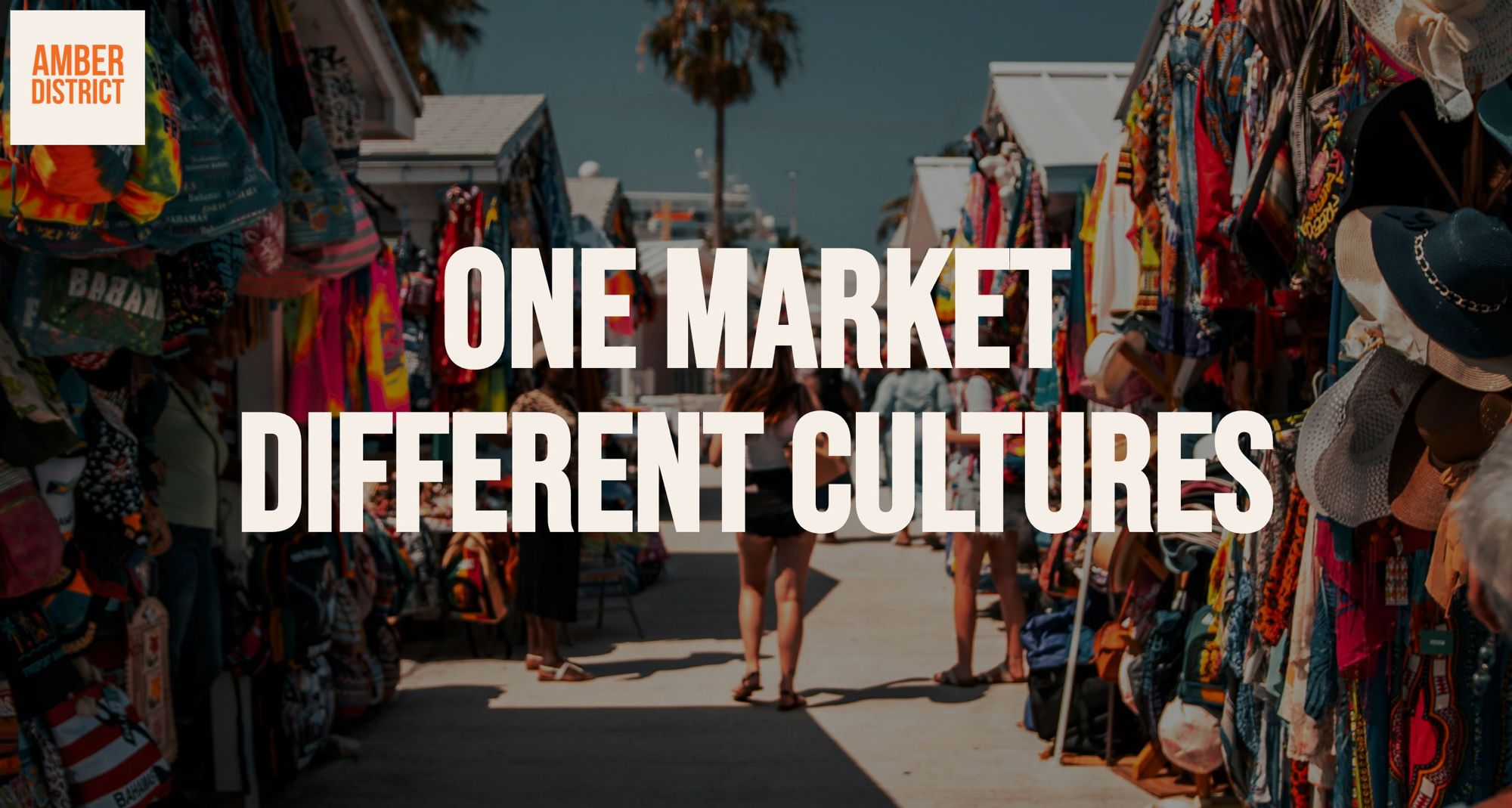 Amber District: One market, different cultures. Shoppers walk between colourful market stalls.