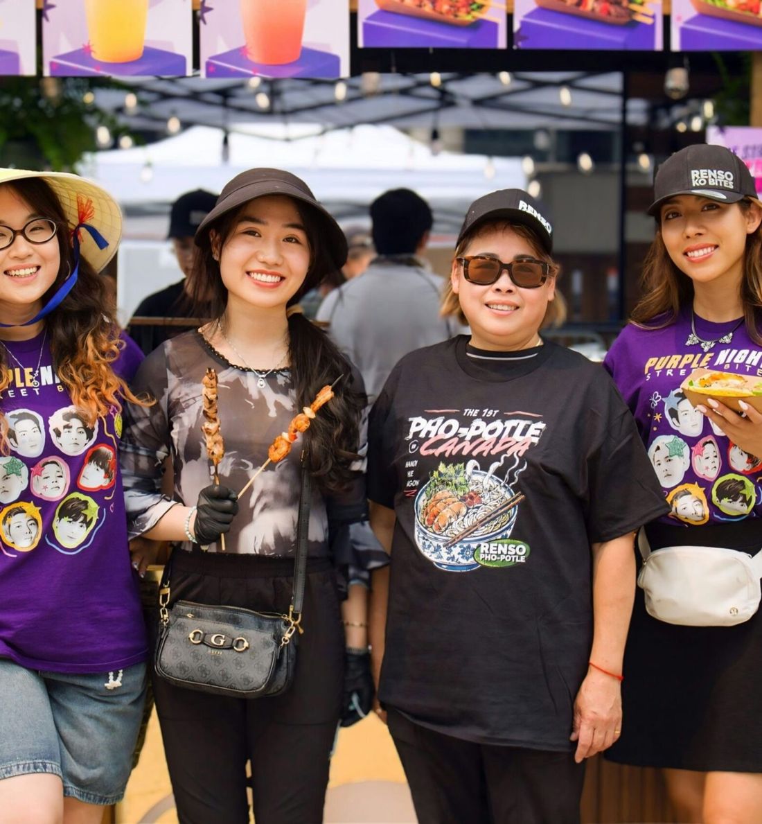 Four vendors smiling at an Amber District market stall
